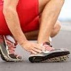 Sports Ankle Injuries - a man touching his injured ankle